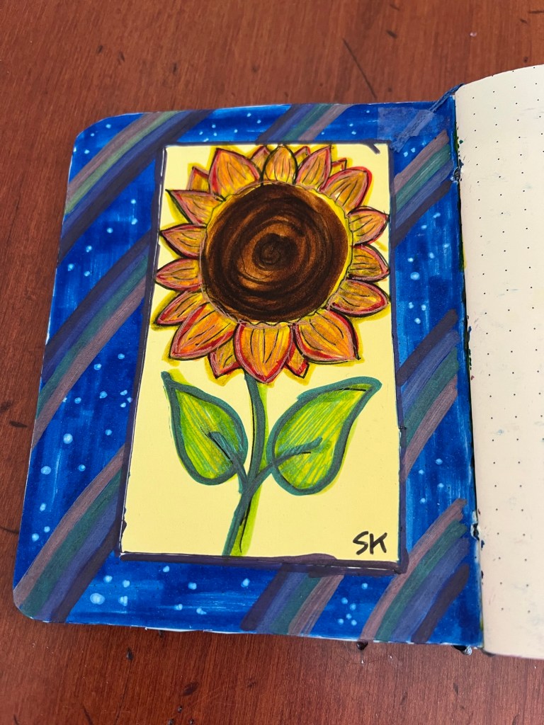 a page of a book decorated with a sunflower and rainbows