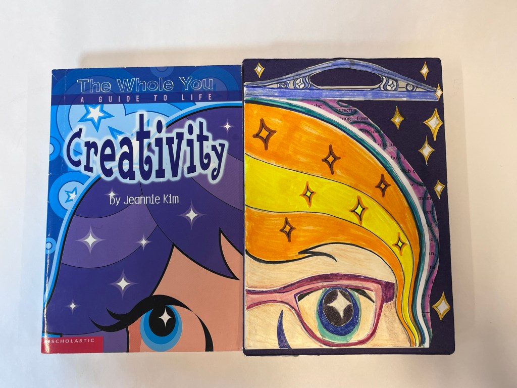 "creativity" book, on the cover of the book is a drawing of a girl's face, which the sophia continued onto the book case in her likeness with the original artist's style
