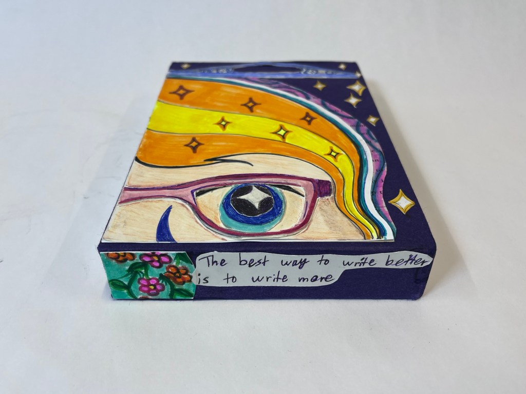 another view of the slipcase showing the bottom of it and a quote reading "the best way to write better is to write more"