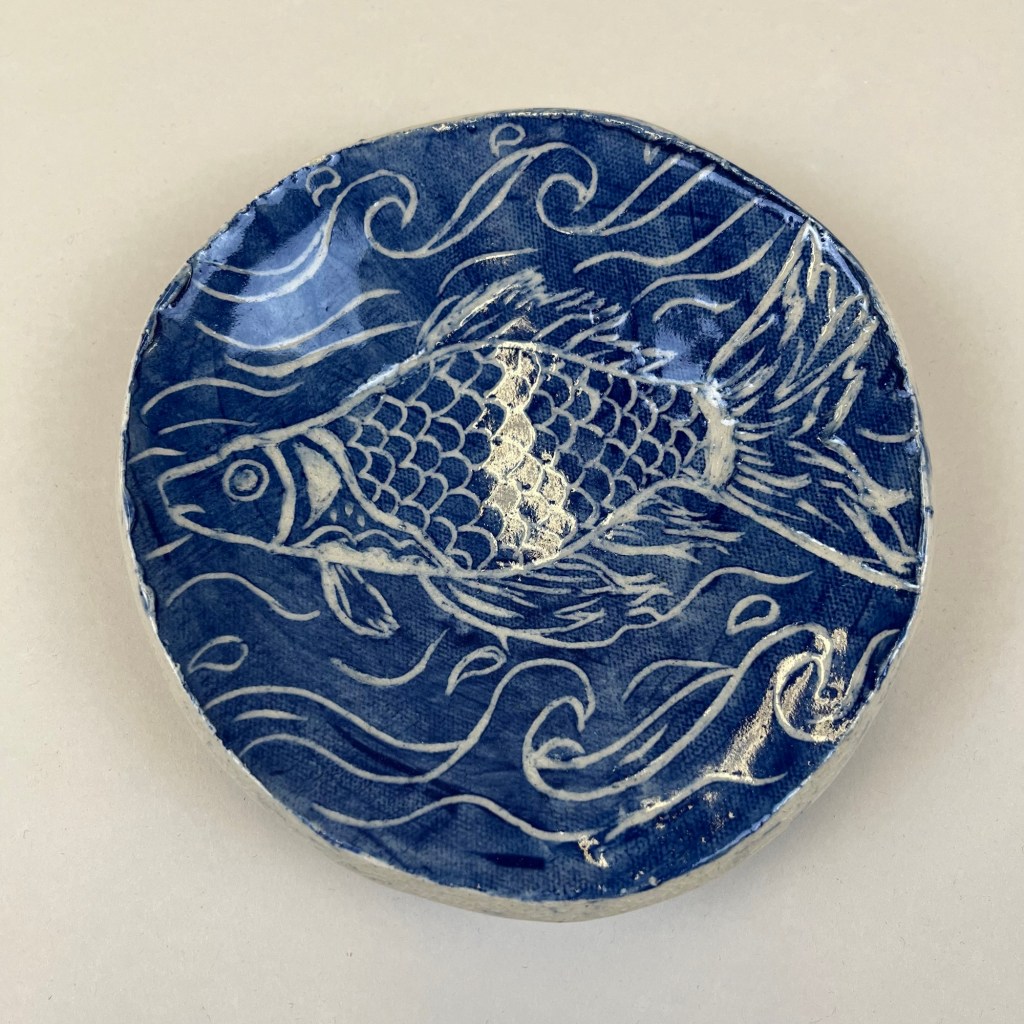 blue plate with a drawing of a fish in the water