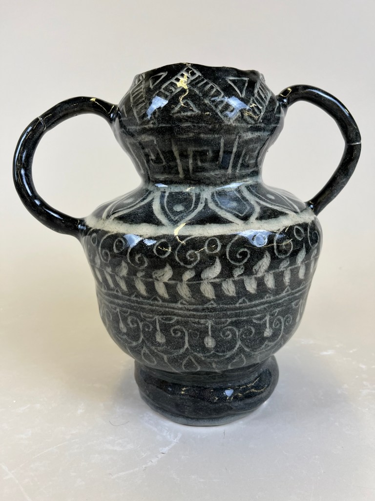 A black and white urn decorated in intricate patterns